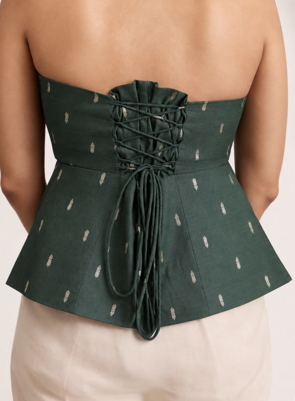 Back view of The Ivy Draped Corset showing the lace-up tie and peplum