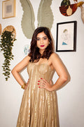 Woman wearing The Lumina Dress by Kashié, a handwoven cotton silk maxi dress with gold zari stripes