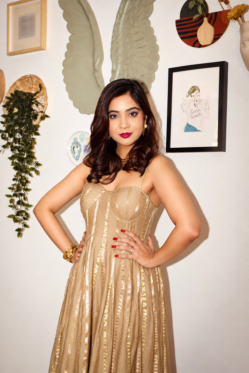 Woman wearing The Lumina Dress by Kashié, a handwoven cotton silk maxi dress with gold zari stripes